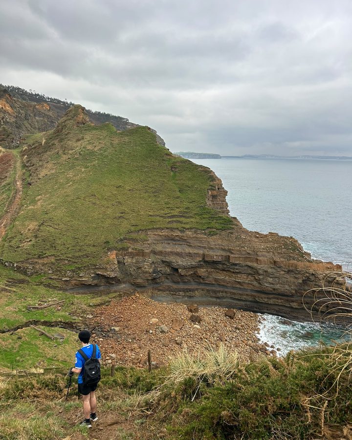 Mario bajando por un camino entre acantilados junto al mar